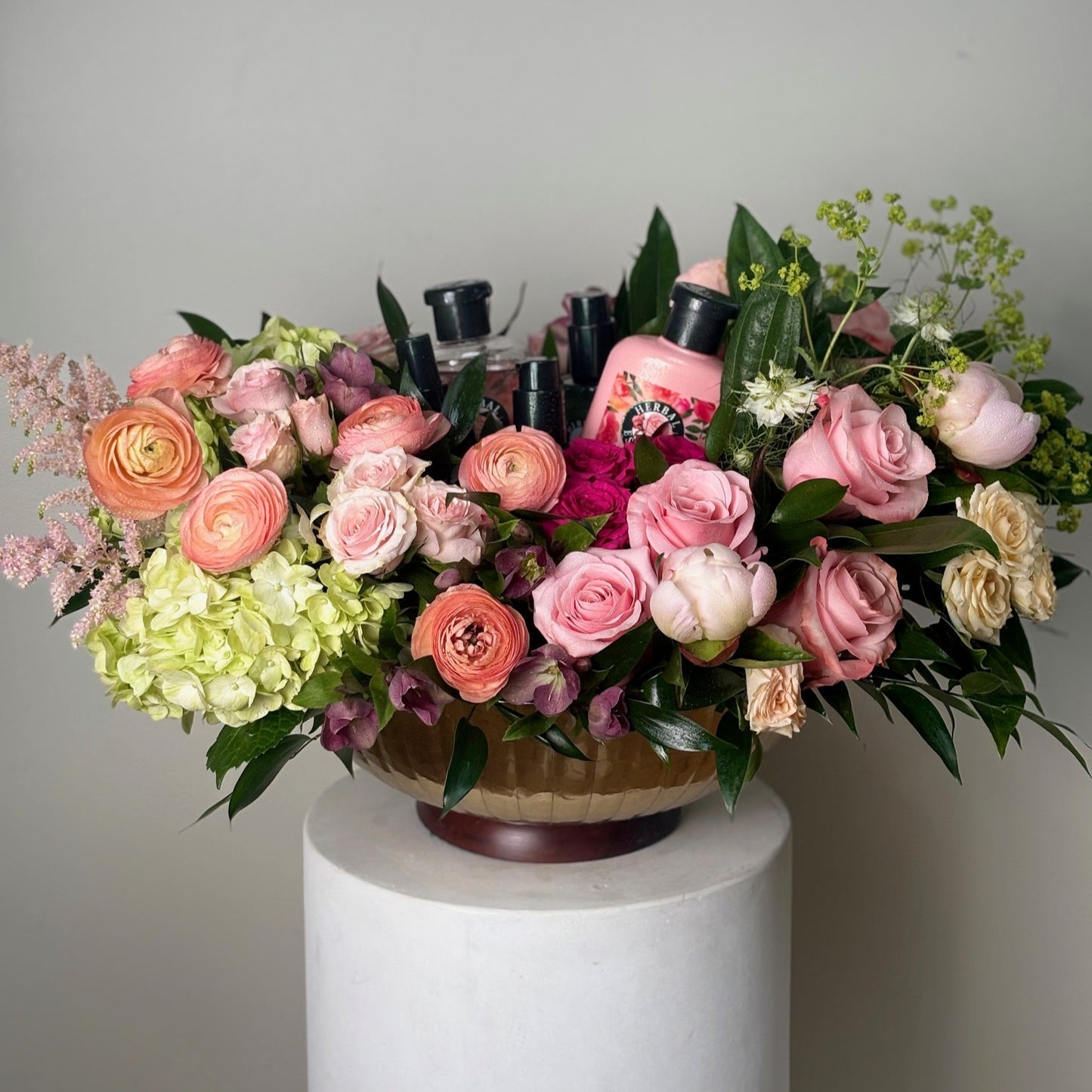 Bouquet of flowers on a white pedestal against a gray background