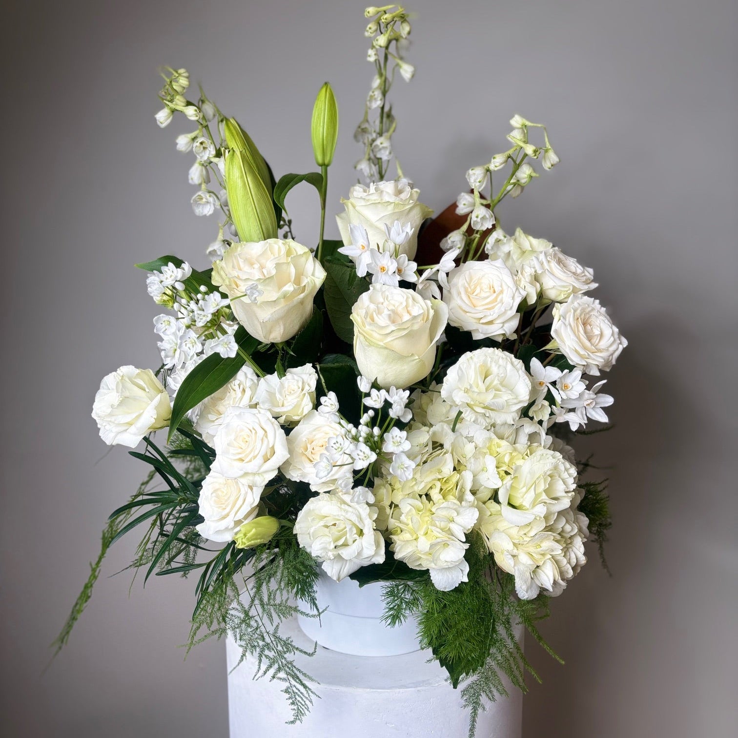 White sympathy flower arrangement on neutral back ground