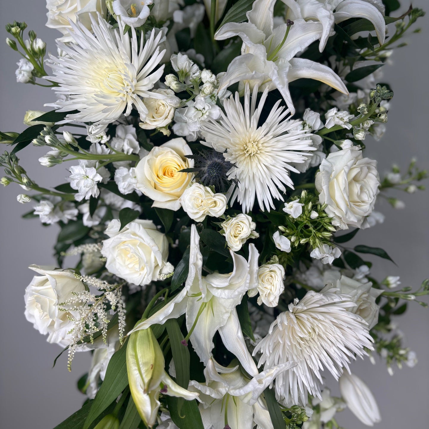 Bouquet of white flowers with greenery on a gray background
