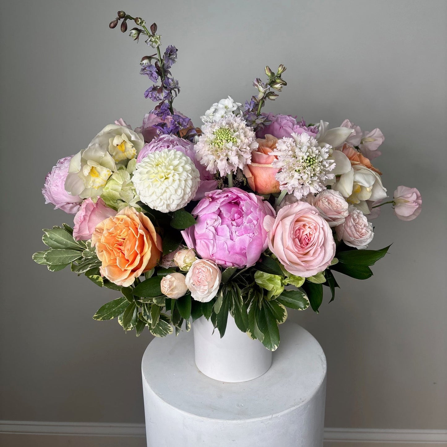 Bouquet of flowers in a white vase against a neutral background