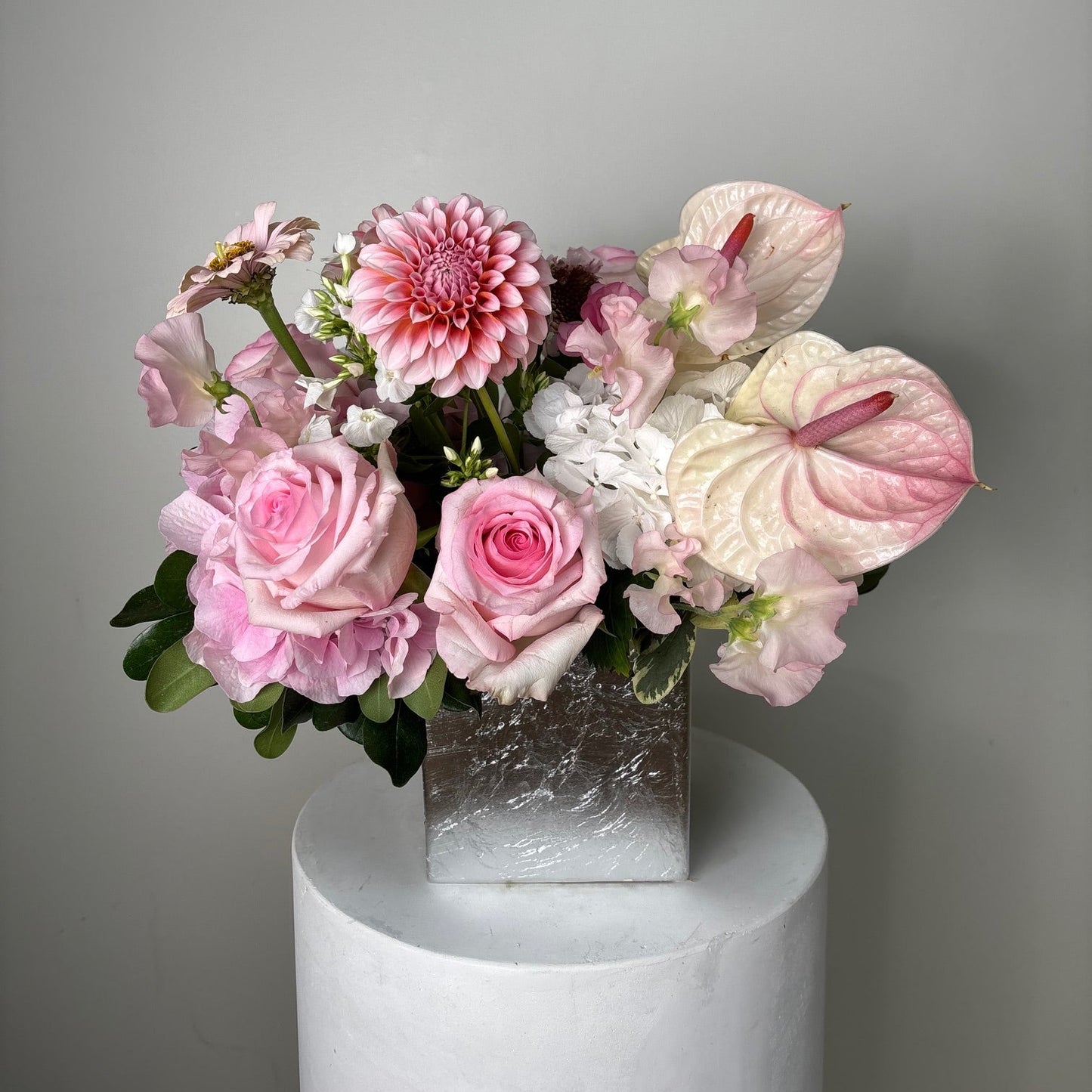 Bouquet of pink flowers with a white vase on a gray background