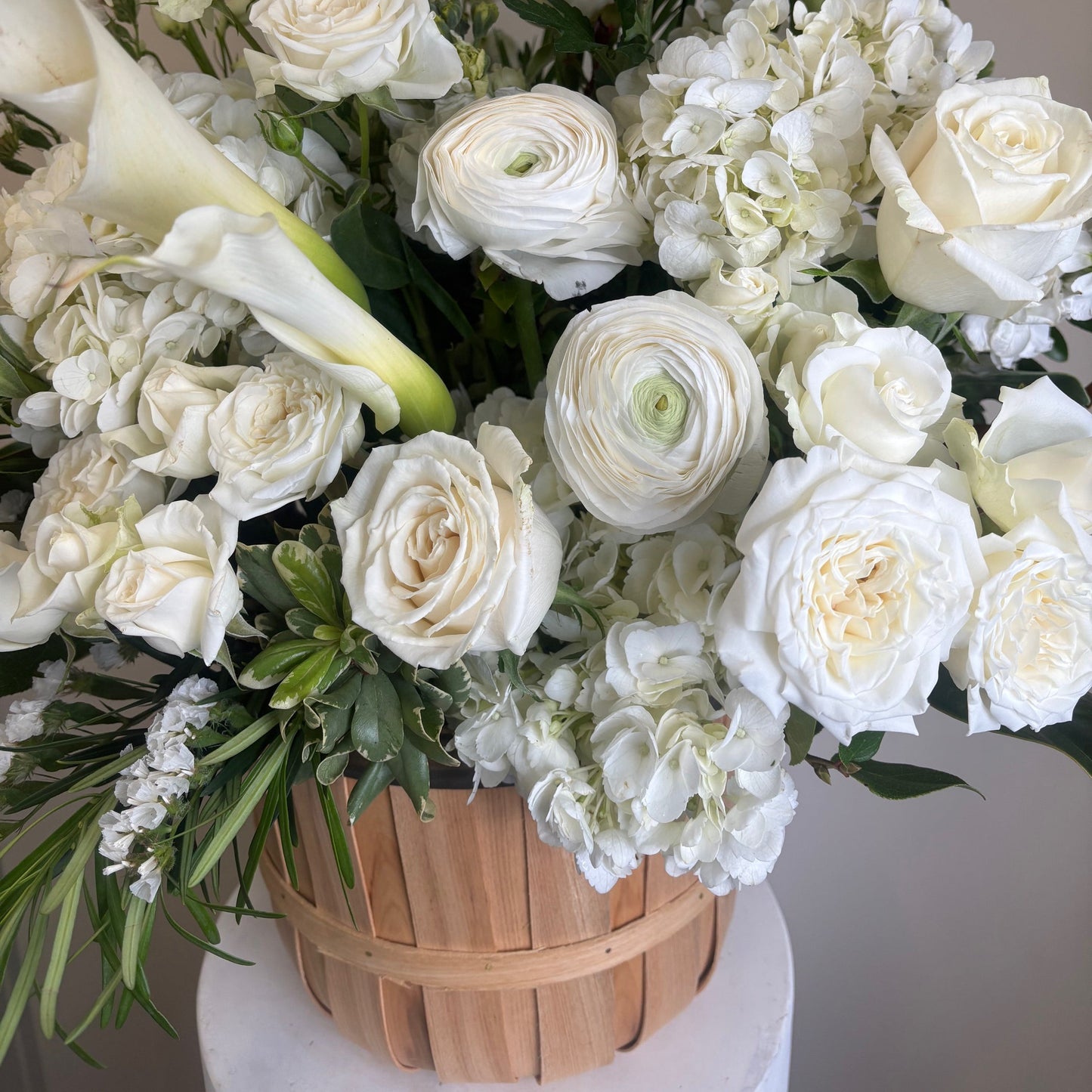 Bouquet of white flowers with a wooden basket in the background