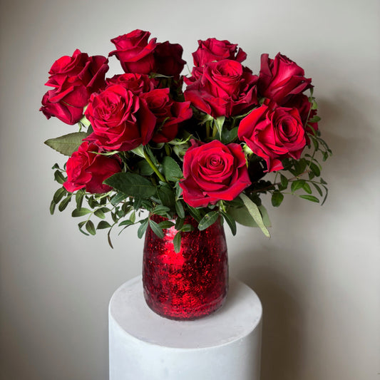 Bouquet of red roses in a white vase on a light background