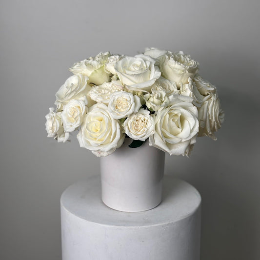 Bouquet of roses in a white vase on a gray background