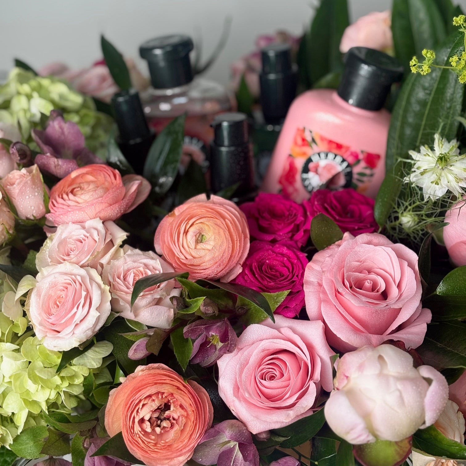 Bouquet of pink and green flowers with shampoo in the background