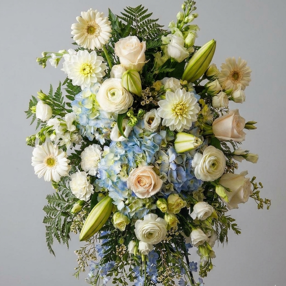 Floral arrangement with a mix of white, green, and blue flowers on a gray background